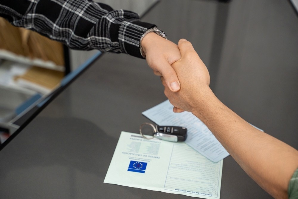 persoane care incheie tranzactia pentru o masina 