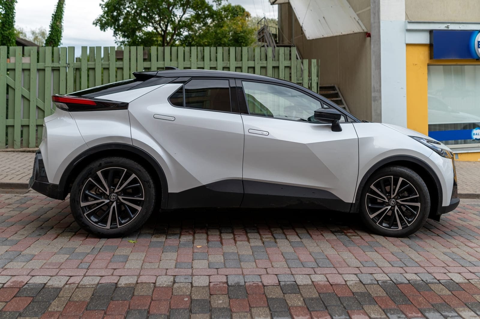 Toyota C-HR alba parcata pe o strada pavata